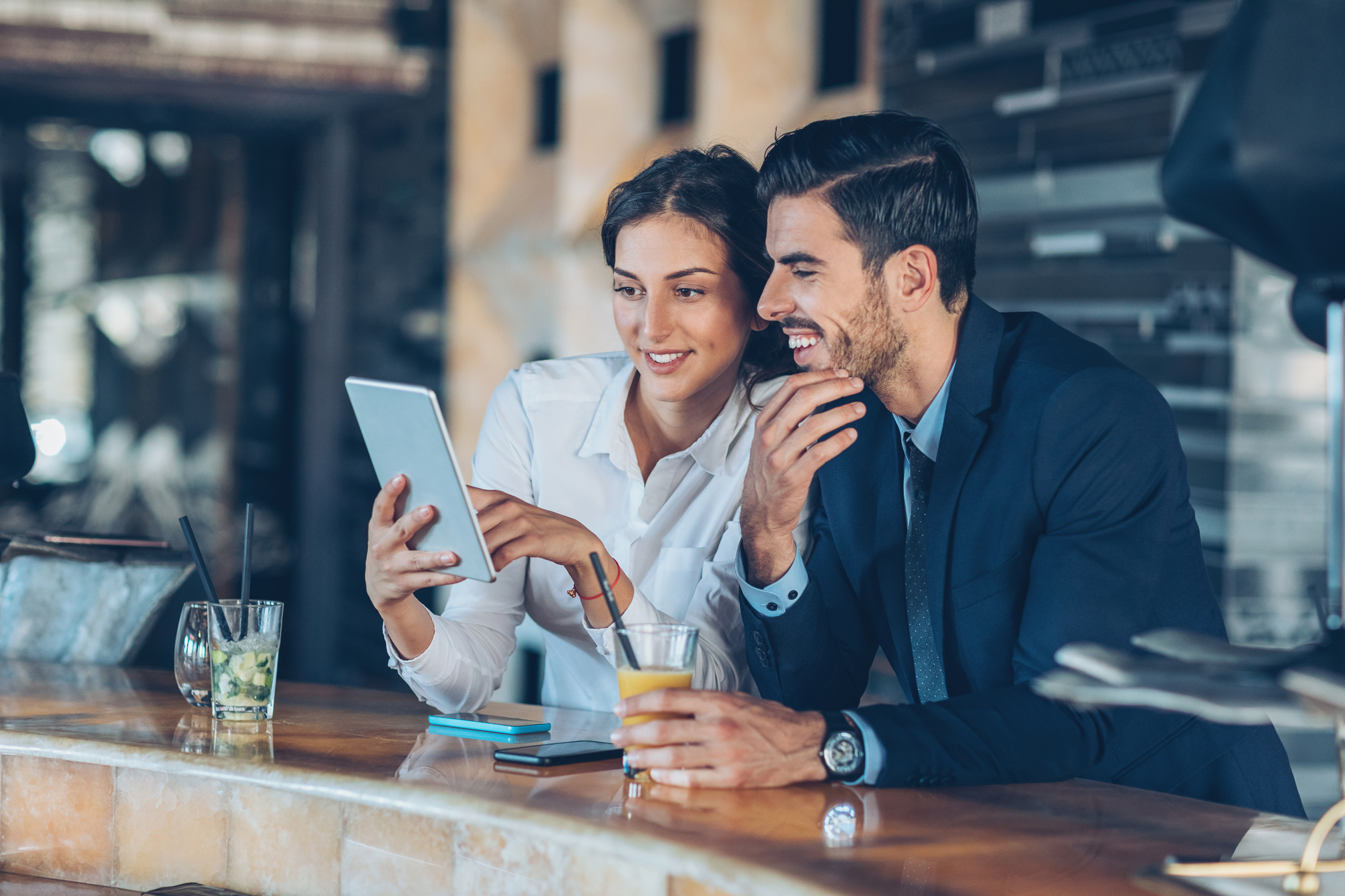 Business persons with digital tablet and drinks in hotel's lobby